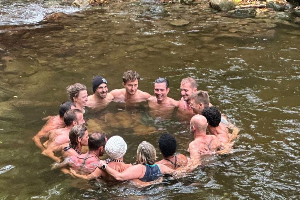 Workshop Gruppe von Anne Passers steht gemeinsam im eiskalten Wasser eines Sees
