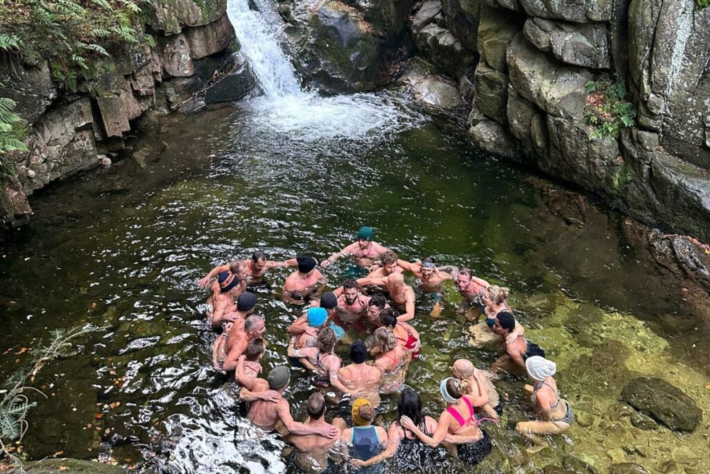 Teilnehmende stehen im kalten Wasser eines Bachlaufs