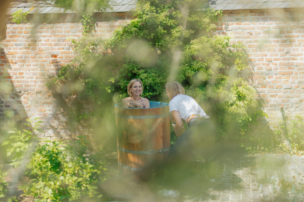 Dr. med. Anne Passers lacht vorgebeugt im Garten