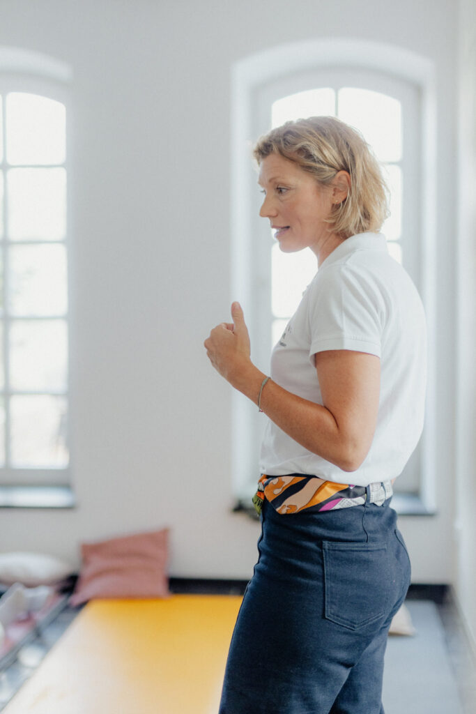Dr. med. Anne Passers präsentiert vor der Leinwand im Firmenseminar