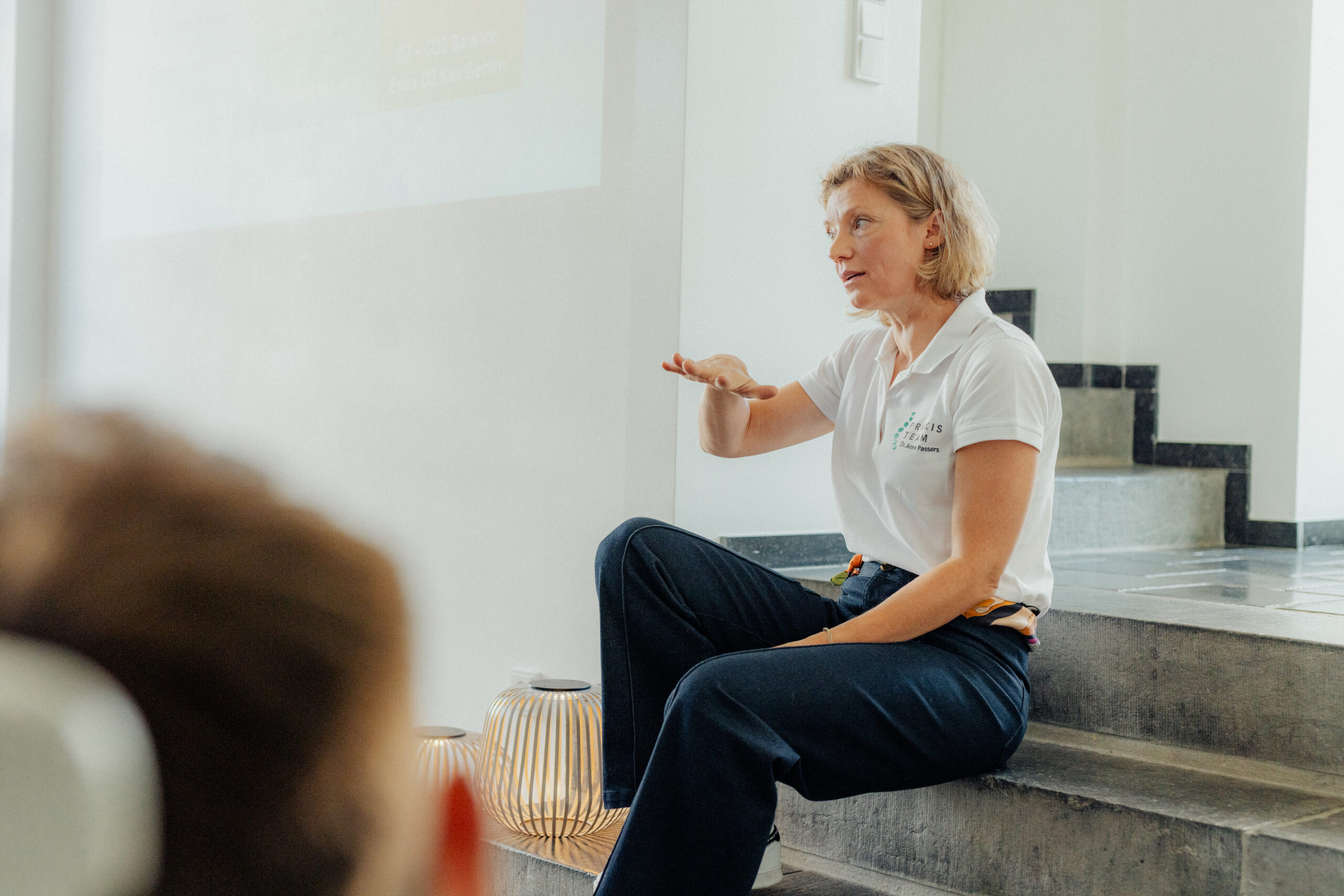Dr. med. Anne Passers erklärt gestikulierend vor einer Gruppe
